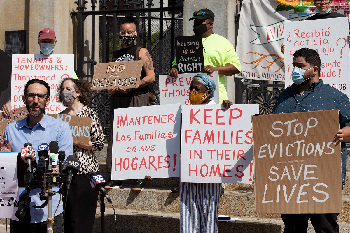 <i>Michael Dwyer/AP</i><br/>People from a coalition of housing justice groups hold signs protesting evictions during a news conference outside the Statehouse