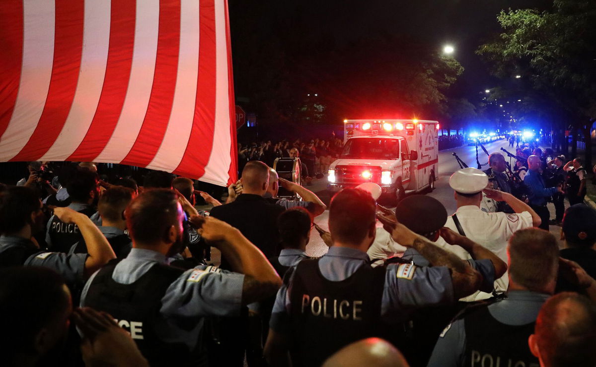 <i>Chris Sweda/TNS/ZUMA Press Wire</i><br/>Chicago police officers salute as the ambulance carrying the body of Officer Ella French arrives at the Cook County medical examiner.