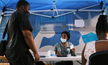 People sign-up for a shot at a city-operated mobile pharmacy for the COVID-19 vaccine in a Brooklyn neighborhood on July 30 in New York City.