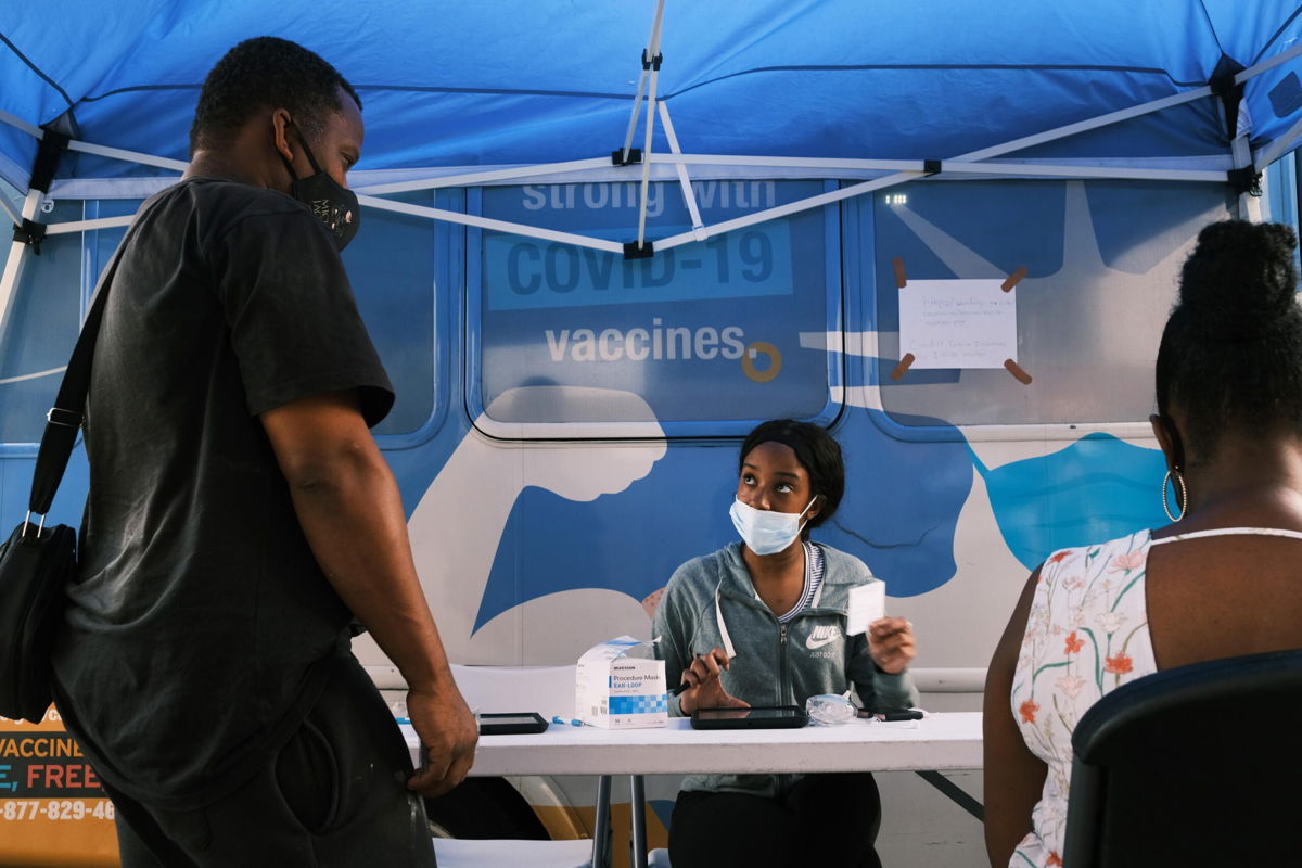 <i>Spencer Platt/Getty Images</i><br/>People sign-up for a shot at a city-operated mobile pharmacy for the COVID-19 vaccine in a Brooklyn neighborhood on July 30 in New York City.