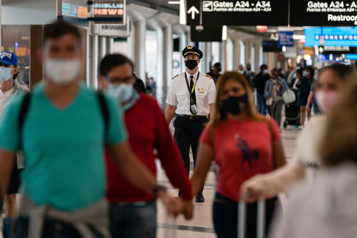 <i>Elijah Nouvelage/Bloomberg/Getty Images</i><br/>People wearing protective masks walk through Hartsfield-Jackson Atlanta International Airport.