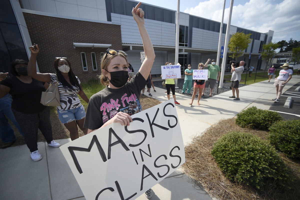 <i>Mike Stewart/AP</i><br/>Pro-mask wearing parents stage a protest at the Cobb County School Board headquarters