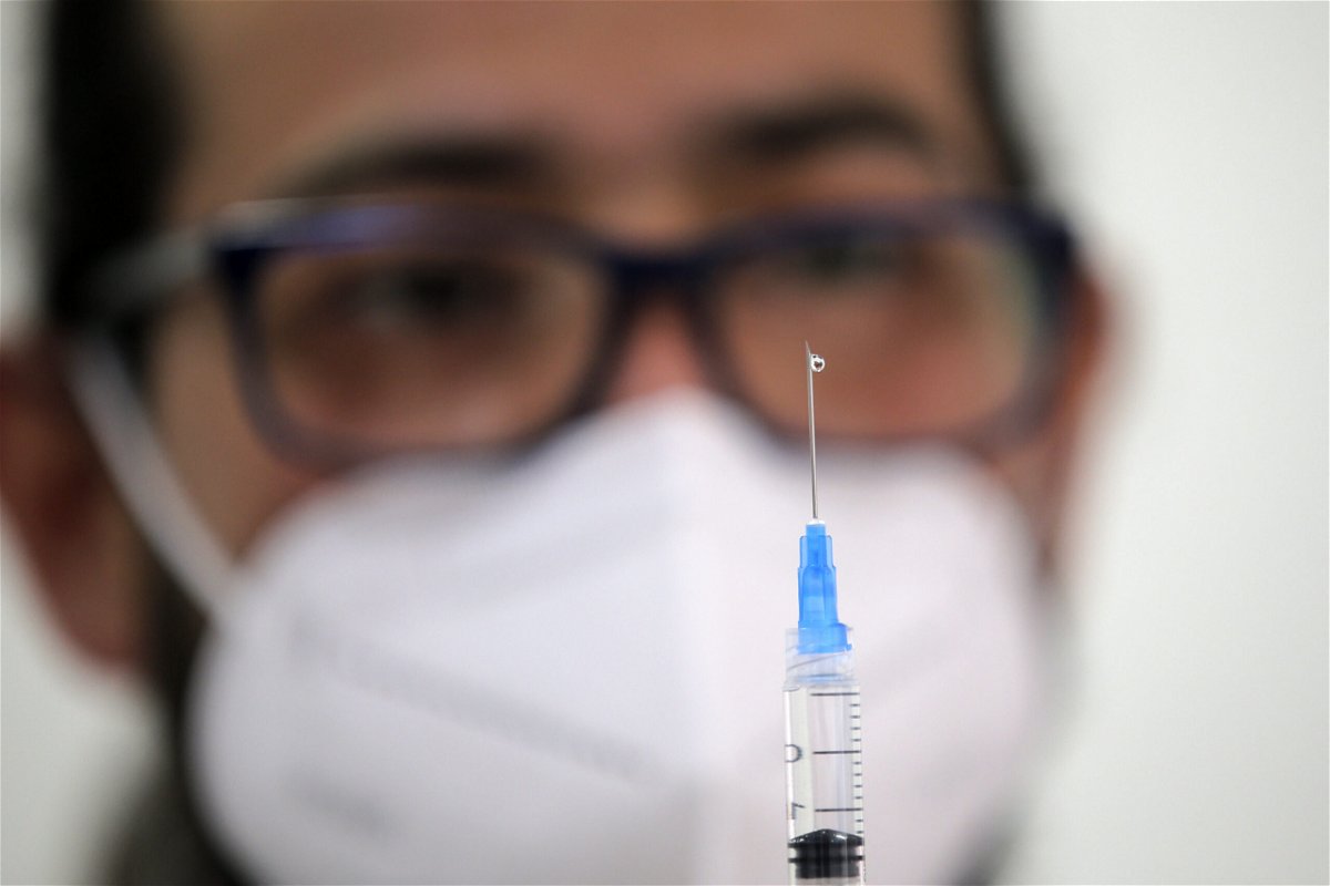 <i>Javier Torres/AFP via Getty Images</i><br/>A health workers fills a syringe with a dose of the Pfizer-BioNTech vaccine against Covid-19 at a vaccination centre in Santiago