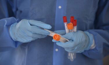 A healthcare worker holds Covid-19 swab tests at a drive-thru testing site in Houston