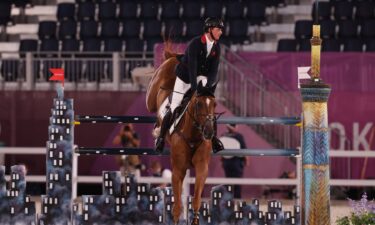 Ben Maher and his horse are part way to landing off a grey and black jump