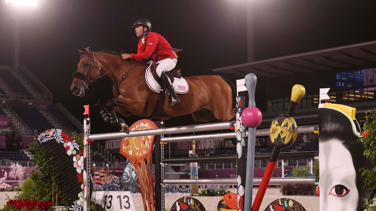 Kent Farrington and his horse jump a painted oxer