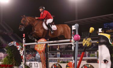 Kent Farrington and his horse jump a painted oxer