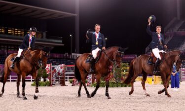 Three Swedish riders smile on their horses and wear medals