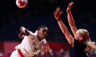 Member of the French handball team hurls the ball while a member of the Swedish handball team attempts to block