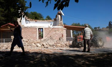 Residents pass next to a damaged Greek Orthodox chapel after a strong earthquake in Arkalochori village on the southern island of Crete