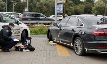 An investigator examines bullet holes in the car of Serhiy Shefir
