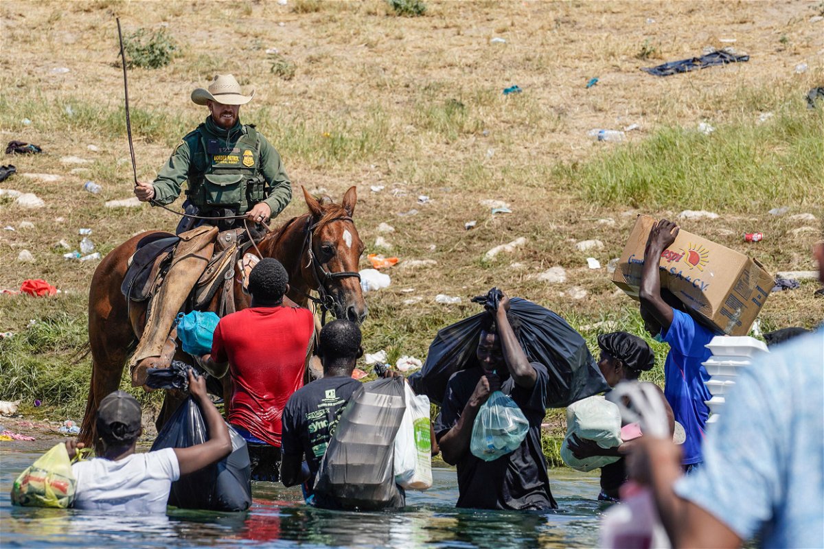 <i>Paul Ratje/AFP/Getty Images</i><br/>A United States Border Patrol agent on horseback uses the reins as he tries to stop Haitian migrants from entering an encampment on the banks of the Rio Grande near the Acuna Del Rio International Bridge in Del Rio
