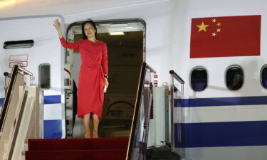 Huawei executive Meng Wanzhou waves as she steps out of an airplane after arriving at Shenzhen Bao'an International Airport in Shenzhen