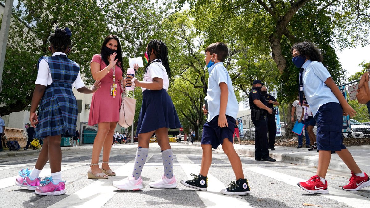 <i>Lynne Sladky/AP</i><br/>Florida Gov. Ron DeSantis has filed an emergency appeal on school mask mandates. A teacher here greets students on the first day of school at iPrep Academy in Miami on August 23.