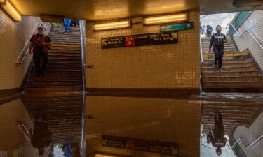 People walk into a flooded subway station in New York City. Heavy rainfall from the remnants of Hurricane Ida disrupted service