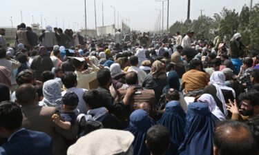 Afghans gather on a roadside near the airport in Kabul on August 20