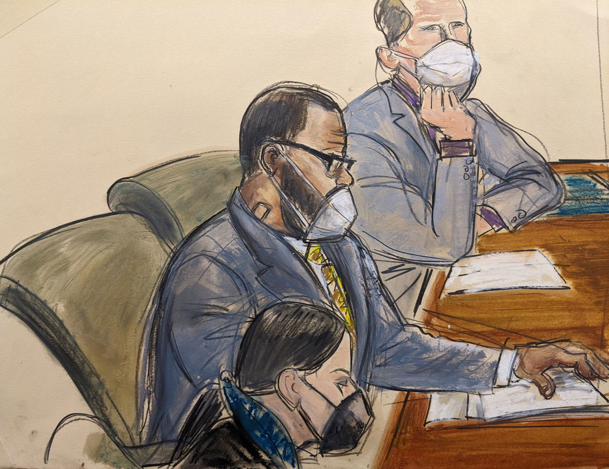 <i>Elizabeth Williams/AP</i><br/>R. Kelly sits with his defense attorneys Thomas Farinella