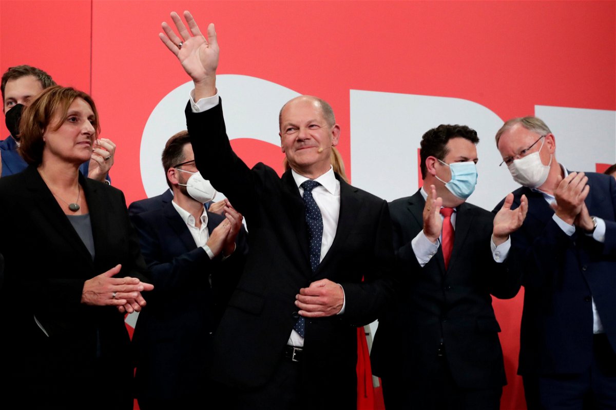 <i>Lisa Leutner/AP</i><br/>SPD's Olaf Scholz waves to his supporters after German parliament election at the party's headquarters in Berlin