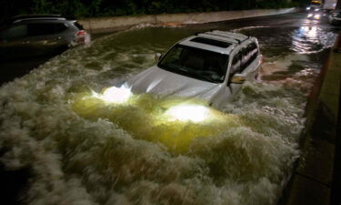 A motorist drives a car through a flooded expressway in Brooklyn