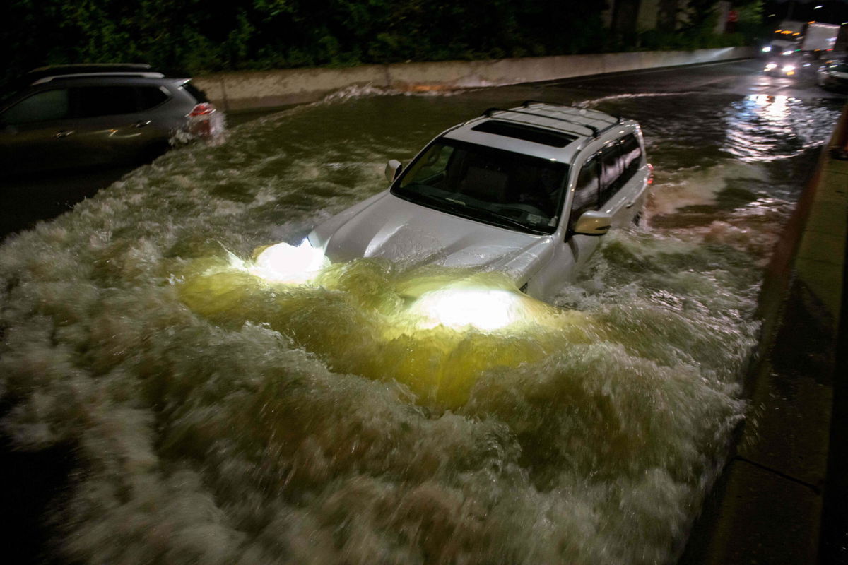 <i>Ed Jones/AFP/Getty Images</i><br/>A motorist drives a car through a flooded expressway in Brooklyn