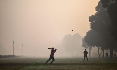 People playing cricket at a park in smoggy conditions in New Delhi on February 8.