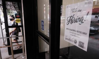 The number of first-time claims for jobless benefits dipped to a new pandemic-era low last week. A hiring sign is displayed in a store window in Manhattan on August 19