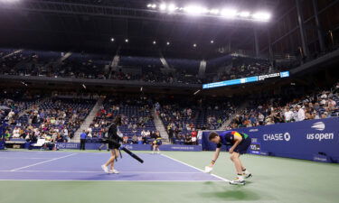 Crew members do their best to dry the court.