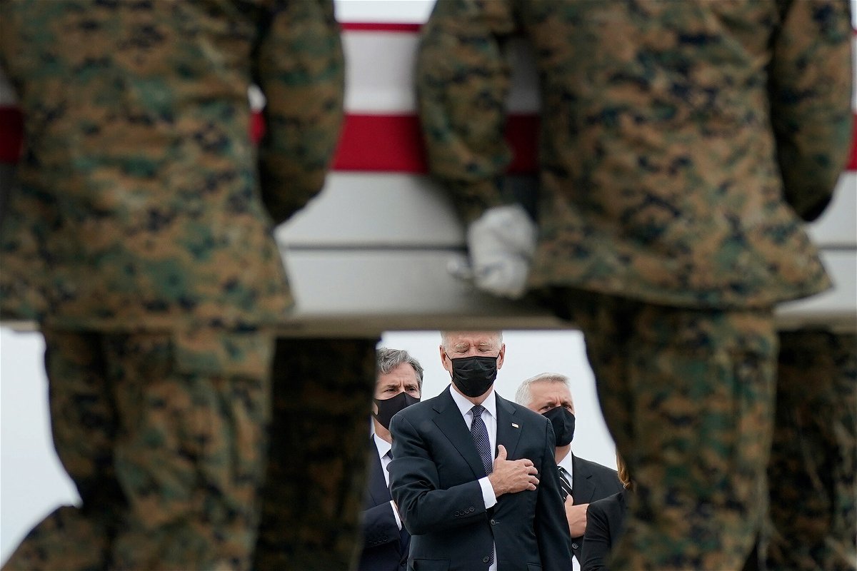 <i>Carolyn Kaster/AP</i><br/>President Joe Biden watches as a carry team moves a transfer case containing the remains of Marine Corps Lance Cpl. Kareem M. Nikoui