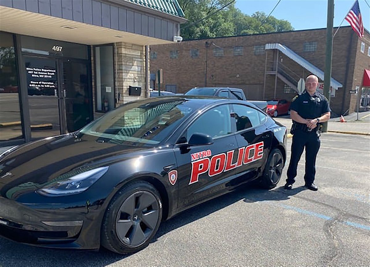 <i>Nitro Police Department/Facebook</i><br/>Patrolman Matt Haynes stands beside the new Tesla Model 3 electric patrol car.