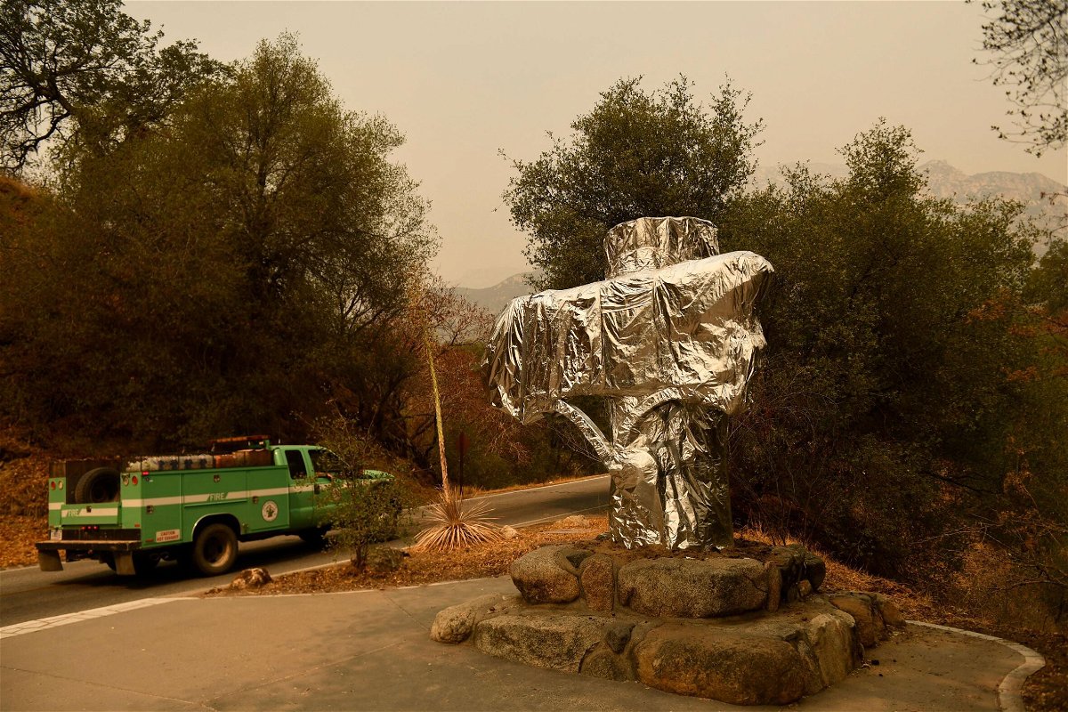 <i>Patrick T. Fallon/AFP/Getty Images</i><br/>A US Forest Service vehicle drives past the Sequoia National Park historic park entrance sign wrapped in fire resistant foil along Generals Highway during a media tour of the KNP Complex fire in the Sequoia National Park near Three Rivers
