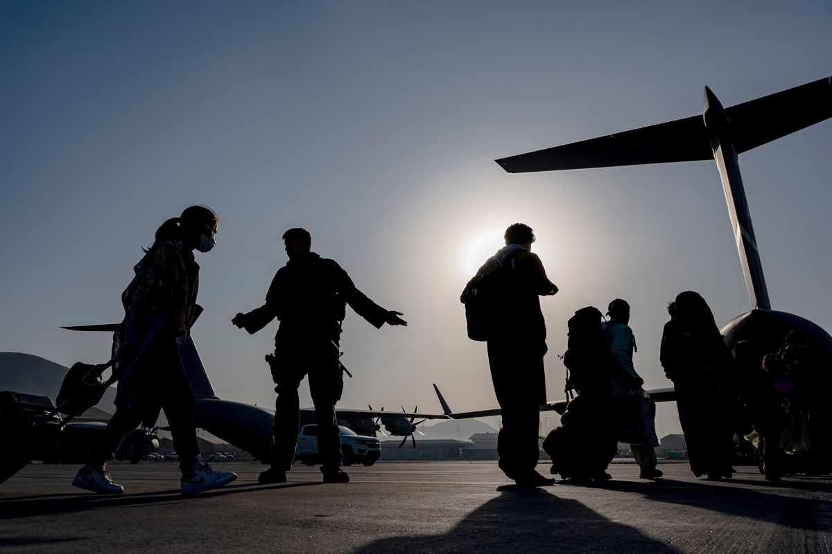 <i>Senior Airman Taylor Crul/AP</i><br/>US Air Force airmen guide evacuees aboard a US Air Force C-17 Globemaster III at Hamid Karzai International Airport in Kabul