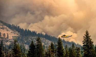 Lighter winds could bring relief to firefighters battling the Caldor Fire. A helicopter here battles the Caldor Fire in Eldorado National Forest