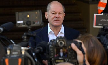 Olaf Scholz speaks to reporters after voting at a polling station in Potsdam