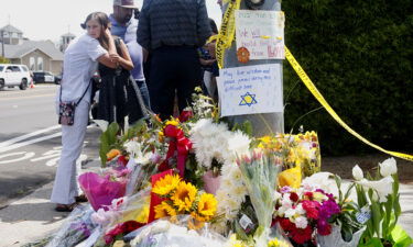 Mourners and well-wishers leave flowers and signs at a makeshift memorial across the street from the Chabad of Poway Synagogue on April 28