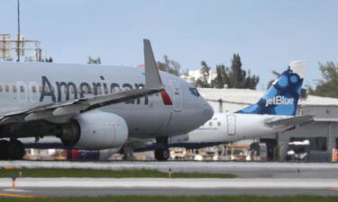 An American Airlines plane takes off near a parked JetBlue plane at the Fort Lauderdale-Hollywood International Airport on July 16