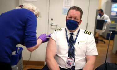 United Airlines pilot Steve Lindland receives a COVID-19 vaccine from RN Sandra Manella at United's onsite clinic at O'Hare International Airport on March 09
