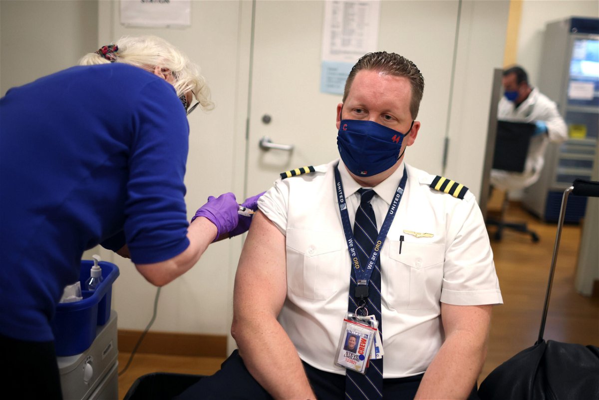 <i>Scott Olson/Getty Images</i><br/>United Airlines pilot Steve Lindland receives a COVID-19 vaccine from RN Sandra Manella at United's onsite clinic at O'Hare International Airport on March 09