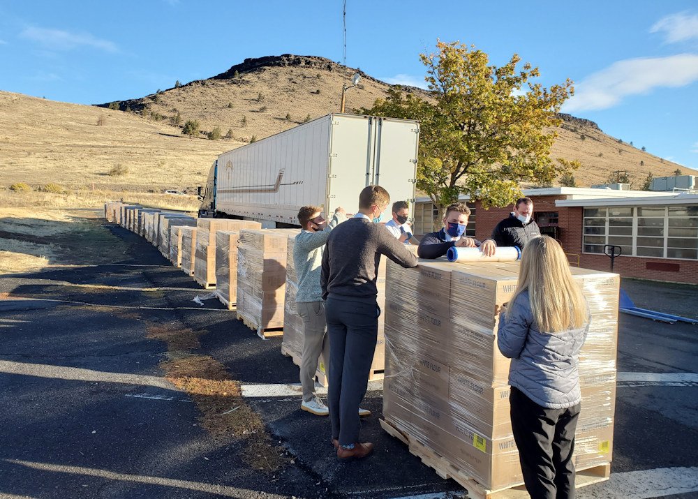 Warm Springs tribal members, church missionaries unload pallets of donated food, supplies