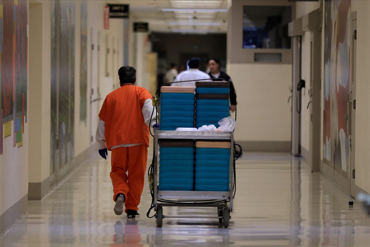 <i>Ted S. Warren/AP</i><br/>A detainee worker moves a cart of trays containing chicken fajita meals to be served to detainees during a media tour of the ICE detention center in Tacoma