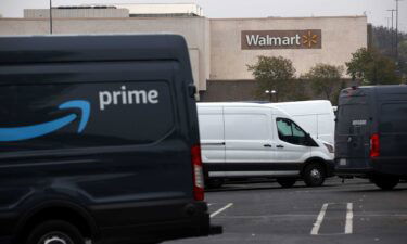 Amazon Prime delivery vans sit parked near a Walmart store on September 03