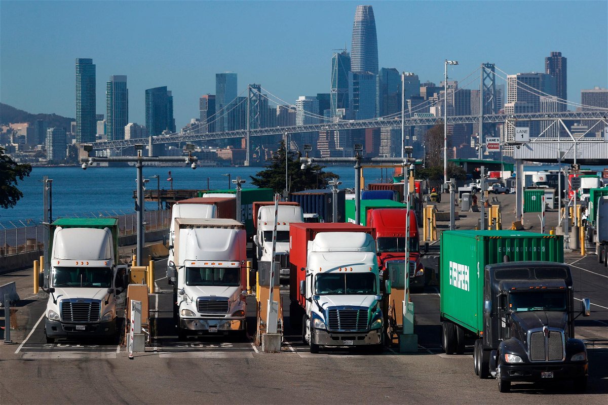 <i>Justin Sullivan/Getty Images</i><br/>Trucks hauling shipping containers leave the EverPort terminal at the Port of Oakland on October 14