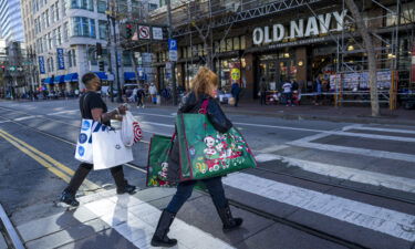 Pedestrians wearing protective masks carry shopping bags in San Francisco