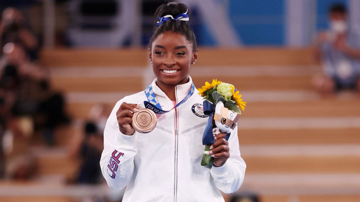 <i>Jamie Squire/Getty Images</i><br/>Simone Biles will be presenting Taylor Swift with the Gracie Grand Award at the Alliance for Women in Media Foundation's 46th Gracie Awards on Tuesday. Biles is shown here with the bronze medal during the Women's Balance Beam Final medal ceremony in August.