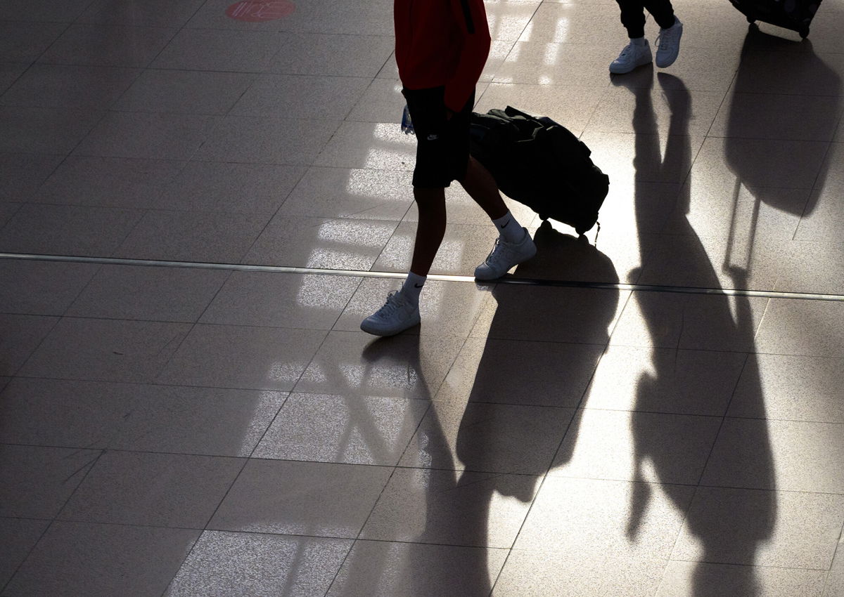 <i>Jonas Walzberg/picture alliance/Getty Images</i><br/>Two young men walk through Terminal 1 with their suitcases on June 25 2021 in Hamburg