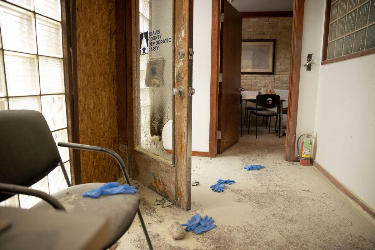 <i>Jay Janner/Austin American-Statesman/USA Today Network</i><br/>A rock remains on the floor at the Travis County Democratic Party office in Austin after someone threw a rock and an incendiary device into the building.