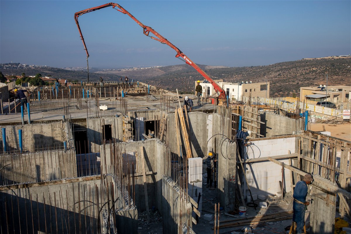<i>Ariel Schalit/AP</i><br/>Palestinian laborers build new houses in the West Bank Jewish settlement of Bruchin on Monday