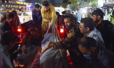 Volunteers and medical staff unload bodies from a pickup truck outside a hospital after the explosion outside the airport in Kabul on August 26
