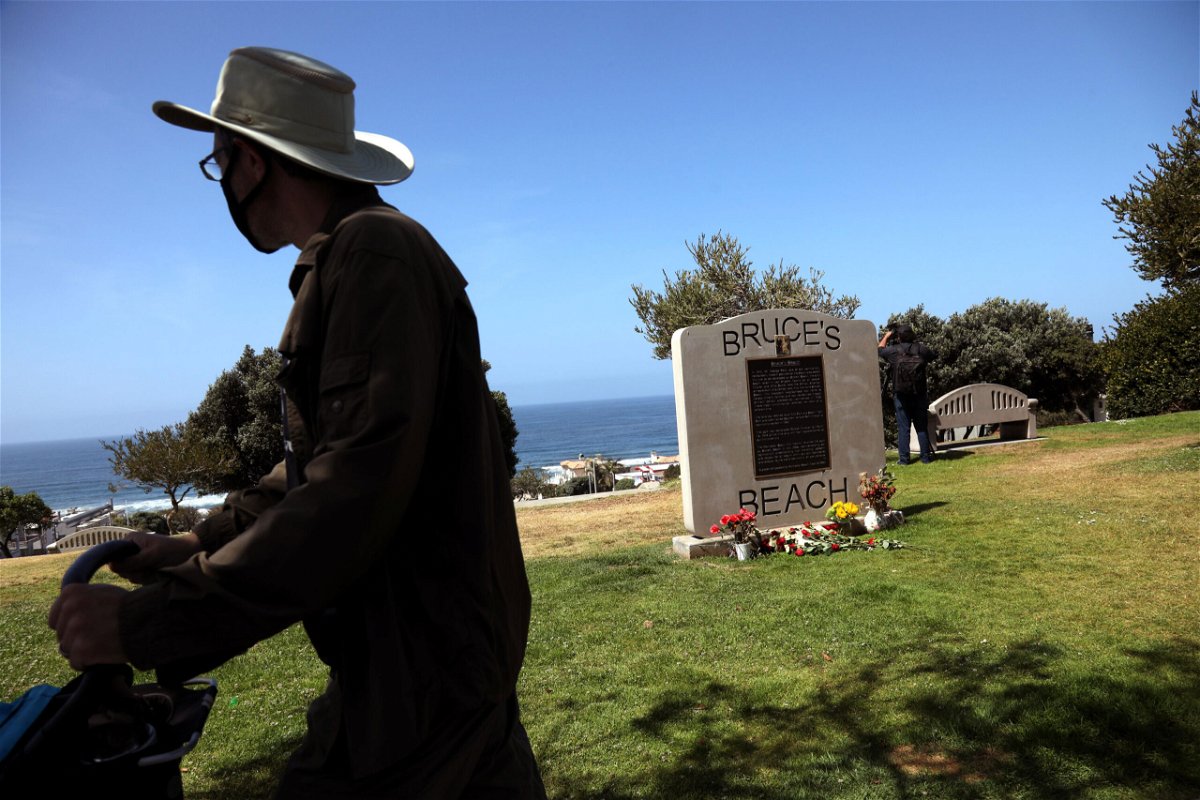 <i>Genaro Molina/Los Angeles Times/Getty Images</i><br/>A pedestrian walks past a historical marker in Manhattan Beach