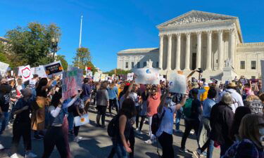 Demonstrators march past the Supreme Court in the nationwide Women's March on October 17
