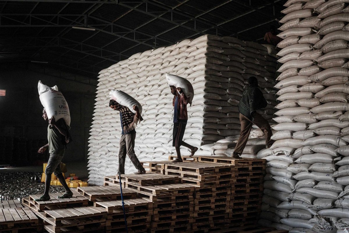 <i>YASUYOSHI CHIBA/AFP/Getty Images</i><br/>Workers carry sacks of wheat from stocks for a food distribution for 4503 people who fled the violence in Ethiopia's Tigray region.